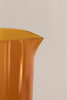 an orange glass vase sitting on top of a table