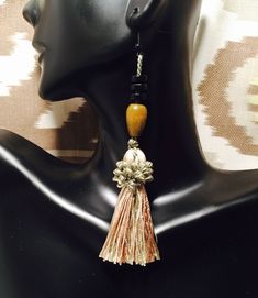 Beautiful unique tassels accented by brown and black wooden beads. Tassel is made with variations of teal, caramel brown, and teal for a neutral color effect. Nickel and lead free fish hook. 100% Rayon tassels. Hangs 4.5". Beach Jewelry With Brown Tassels, Bohemian Brown Beaded Tassel Earrings, Adjustable Brown Beaded Earrings With Dangling Beads, Elegant Brown Dangle Tassel Earrings, Brown Dangle Tassel Earrings With Fringe, Adjustable Brown Bohemian Tassel Earrings, Brown Fringe Dangle Tassel Earrings, Brown Dangle Earrings With Tassels, Brown Fringe Tassel Dangle Earrings