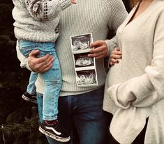 a man, woman and child standing in front of a christmas tree holding an x - ray