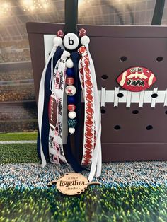 two baseball bracelets are on display in front of a football field and stadium sign