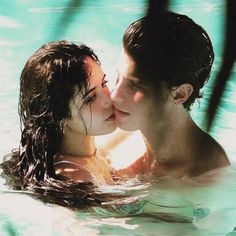 a man and woman are kissing in the water