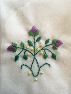 a close up of a piece of cloth with flowers embroidered on the front and back