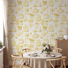 a dining room with a table and chairs in front of a wallpapered wall