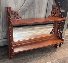 a wooden shelf with two mirrors on top of it