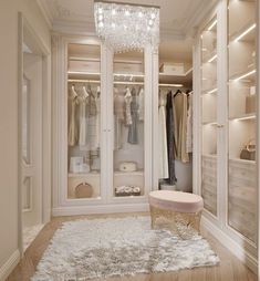 a walk - in closet with chandelier and dressing room furniture on the floor