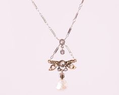 Item Description: This 1870s Victorian Dragonfly motif Necklace features a Natural Free Form Pearl and Old Mine Diamonds in 14 Karat White Gold and Platinum. A Diamond Dragonfly charm drops from the chain and suspends a diamond and pearl charm. The Natural Pearl measures approximately 7.5 millimeters and is Iridescent White with pinks and blues. It has natural rippling and dimpling. This delicate necklace measures 16 inches long and has a safety clasp for extra security. This piece shows that hi Victorian White Gold Pendant Necklace, Antique White Gold Pendant Necklace, Antique Yellow Gold Necklace With Historical Design, Victorian Pendant Necklace With Historical Design, Antique White Gold Necklace With Pearl Pendant, Victorian Hallmarked Diamond Necklace, Antique Evening Necklace With Rose Cut Diamonds, Antique Rose Cut Diamond Necklaces For Evening, Antique Necklace With Historical Design For Formal Events