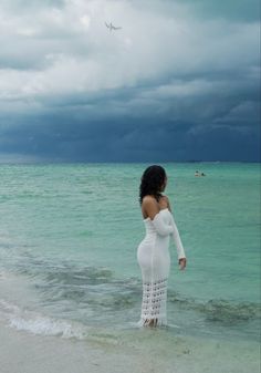 a woman standing in the water at the beach