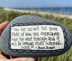 a hand holding a rock with a poem written on it