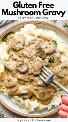 a white plate topped with mashed potatoes covered in mushroom gravy and a fork