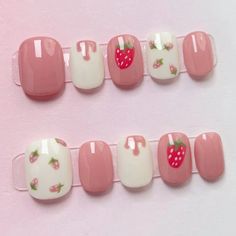 two rows of pink and white nails with strawberrys on them