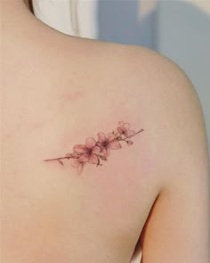 the back of a woman's shoulder with pink flowers on her left arm and chest