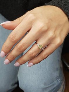 a woman's hand wearing a yellow diamond ring