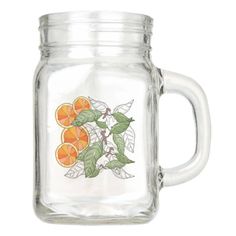 a glass jar with oranges and leaves on it