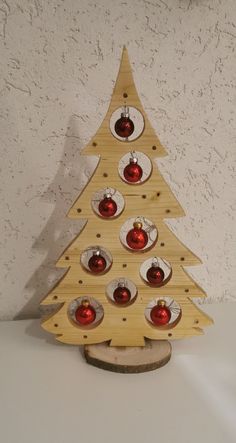 a small wooden christmas tree with red ornaments