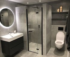 a bathroom with a toilet, sink and shower stall in the middle of it's walls