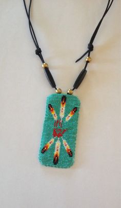 a necklace made with beads and beading on a white surface, featuring an image of a person's hand