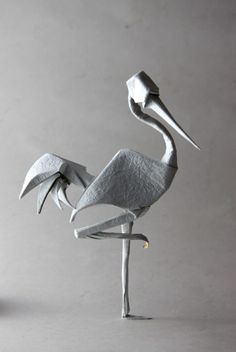 a sculpture of a white bird on a metal stand with its wings spread out and it's head turned to the side