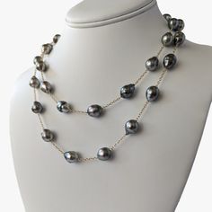 Introducing our exquisite Tahitian Pearl Station Long Necklace, a testament to refined elegance in modern jewelry design. This piece artfully marries the timeless allure of pearls with the luxurious warmth of 14K yellow gold, creating an accessory of modern sophistication. The necklace is 36 inches in length and weighing 46.5 grams, is crafted with meticulous attention to detail. It can be worn long for a more dramatic look, or wrapped double. It features semi-baroque and circled drops Tahitian Elegant Yellow Gold Tahitian Pearl Jewelry, Elegant Single Strand Tahitian Pearl Necklace, Elegant Tahitian Pearl Jewelry With Round Beads, Elegant Gold Tahitian Pearl Necklaces, Elegant Gold Tahitian Pearl Necklace, Elegant Tahitian Pearl Necklace For Formal Occasions, Elegant Tahitian Pearl Necklace With High Luster, Elegant Tahitian Pearl Necklace With Pearl Charm, Elegant Gold Tahitian Pearl Jewelry