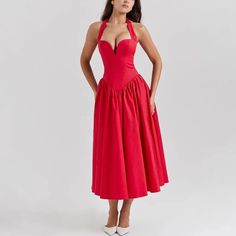 a woman in a red dress posing for the camera with her hands on her hips