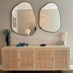 two mirrors on the wall above a dresser