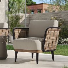 two wicker chairs sitting next to each other on a sidewalk in front of a house