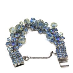 "*Description: This is a beautiful wide blue rhinestone bracelet with aurora borealis accent rhinestones from the 1950s. The unique design has clear glass beads dangling throughout most of the bracelet. The beads look like free form, yet are all uniform in design. They have a slight yellow tint which matches one of the colors in the aurora borealis blue rhinestones. The bracelet has a push box clasp with three rhinestones on top of the clasp. This bracelet would be beautiful for a wedding, \"som Vintage Jeweled Crystal Bracelets, Vintage Crystal Bracelet For Party, Vintage Blue Rhinestone Jewelry, Vintage Blue Bracelets For Party, 1950s Bracelet, Formal Earrings, Vintage Christmas Gifts, Book Pieces, Clear Beads