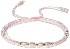 a pink bracelet with pearls and gold beads on it's end, in front of a white background