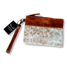 Handcrafted, Functional and Stunning. This eye catching wristlet clutch is meant for that perfect night out on the town. The beautiful genuine cowhide plus our top grain leather stands out in a crowd and is sure to be a show stopper. This wristlet is just the right size to become your go to favorite to complete that perfect outfit. From day to night this bag is perfect! Please note as cowhide is a natural material each bag is one of a kind and the pattern will differ on each Duffel Weekender. Ju Leather Pouch With Wrist Strap, Leather Wristlet Clutch With Wrist Strap, Leather Wristlet With Wrist Strap, Leather Clutch Wristlet For Gifts, Leather Clutch With Wrist Strap, Leather Clutch Wristlet With Wrist Strap, Chic Leather Clutch Wristlet, Brown Leather Wristlet With Removable Pouch, Leather Rectangular Wristlet With Zipper Pouch