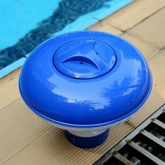 a blue object sitting on the side of a swimming pool next to a grate