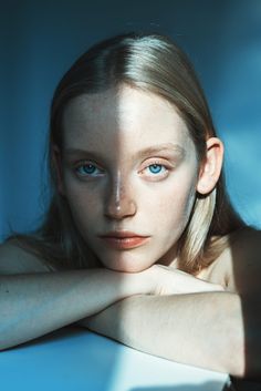 a woman with blue eyes is posing for the camera