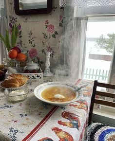 a table topped with a bowl of soup next to a plate of bread