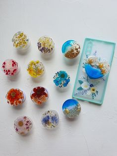 an assortment of glass knobs with flowers on them sitting next to a framed mirror