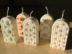 four decorative candles are sitting on a table