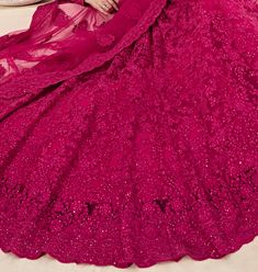 COLOR : Magenta Pink FABRIC : Top (Blouse) - Net, Bottom (Lehenga) - Net, Inner - Silk Satin & Premium Can-Can, Dupatta - Net WORK : Heavy Silk Thread Embroidery, Heavy Stone Work, Cutwork, Cording Embroidery OCCASION : Wedding, Reception, Sangeet, Engagement READY-TO-WEAR : NoSTITCHING : Available as semi-stitched fabric, can be stitched using standard size option (+$30). Note: There might be a slight color variation due to lighting and flash used during photoshoot. The bright shade seen is the Fitted Pink Embroidered Fabric For Navratri, Fitted Embroidered Lace Sharara, Pink Fitted Saree With Embroidered Pallu, Bollywood Style Pink Embroidered Fitted Fabric, Fitted Lace Lehenga With Intricate Embroidery, Pink Embroidered Bollywood Style Fitted Fabric, Bollywood Lace Gown For Festive Season, Bollywood Style Festive Lace Gown, Festive Bollywood Lace Gown