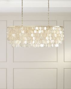 a chandelier hanging from a ceiling in a room with white paneled walls