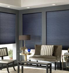 a living room filled with furniture and windows covered in shades