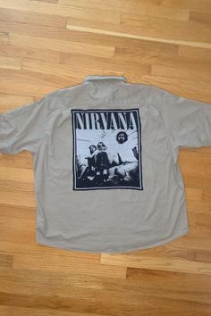 One-of-a-kind Short Sleeve Button-up featuring the band, Nirvana!  Thrifted and Prewashed 98% cotton & 2% Spandex button-up with thrifted t-shirt print stitched to the back.   Size 3X-Large  Measurements: ♥  Shoulders: 22.75" ♥  Chest: 30" ♥  Sleeve: 11.5" ♥  Length: 27.5" . . . . . . . . . . . . . . . . . . . . . . . . . . . . . . . . . . . . . . . . . . . . . Handmade ♥ Thrifted ♥ Recycled ♥ Upcycled These shirts are created with button-ups and shirts that need a second life and once they are combined they become unique one of a kind items!  The shirts are MEN'S sizes but can be worm by both men and women!  For a more baggy, comfy, and oversized fit, order a size up from your regular size. . . . . . . . . . . . . . . . . . . . . . . . . . . . . . . . . . . . . . . . . . . . . . If you ha Vintage Short Sleeve Button Up, Vintage Graphic Print Camp Shirt For Streetwear, Oversized Cotton Button-up Camp Shirt, Vintage Collared Camp Shirt For Streetwear, Vintage Buttoned Tops For Streetwear, Vintage Cotton Shirt For Festivals, Vintage Camp Shirt With Relaxed Fit For Streetwear, Vintage Relaxed Fit Camp Shirt For Streetwear, 90s Style Cotton Button-up Shirt