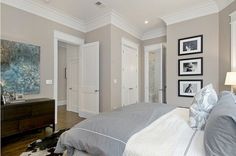 a bedroom with gray walls and pictures on the wall