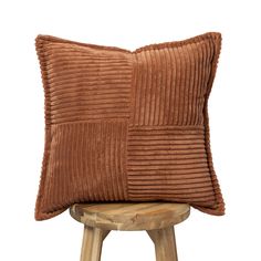 a brown pillow sitting on top of a wooden stool