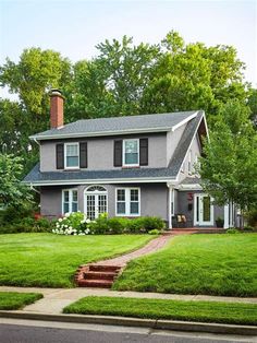 a large gray house sitting on the side of a road