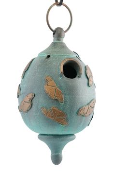 a blue birdhouse with gold butterflies on it's sides and a round hole in the middle