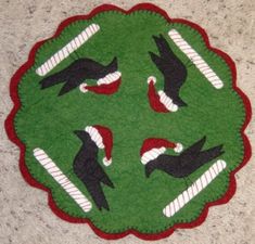 a green rug with black and white birds on it's face in the middle