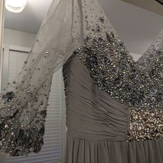 two dresses hanging up in front of a window