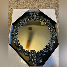 a mirror with skulls on it is in a box that has been cut out to look like an octagon