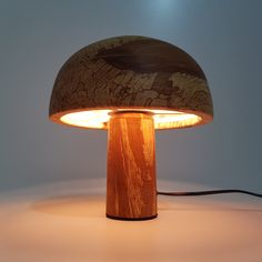 a wooden table lamp with a light on it