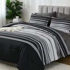 a bed with black and grey striped comforters