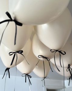 white balloons tied with black ribbon hang from the ceiling