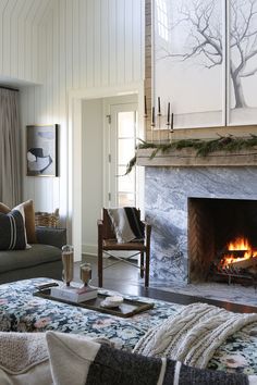 a living room filled with furniture and a fire place next to a fireplace covered in blankets