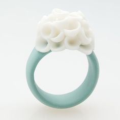 a close up of a ring with flowers on the front and side, against a white background