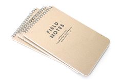 three notebooks sitting next to each other on top of a white surface with the words field notes written in black